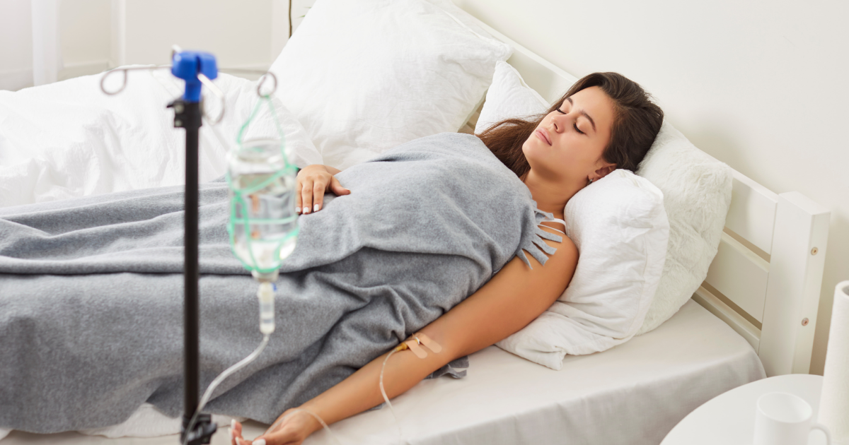 Young woman receiving Vitamin B12 injections IV therapy while resting in bed in Waycross, GA
