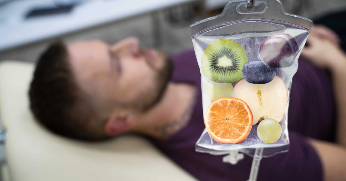 IV bag containing fruit slices with a man lying down in the background, representing IV Infusion Therapy in Waycross, GA.